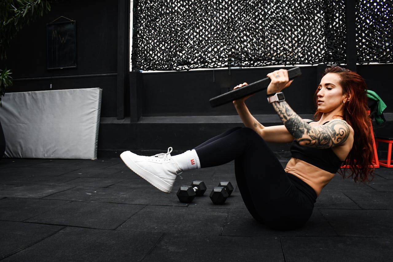 A determined woman performs a core workout in an indoor gym setting.